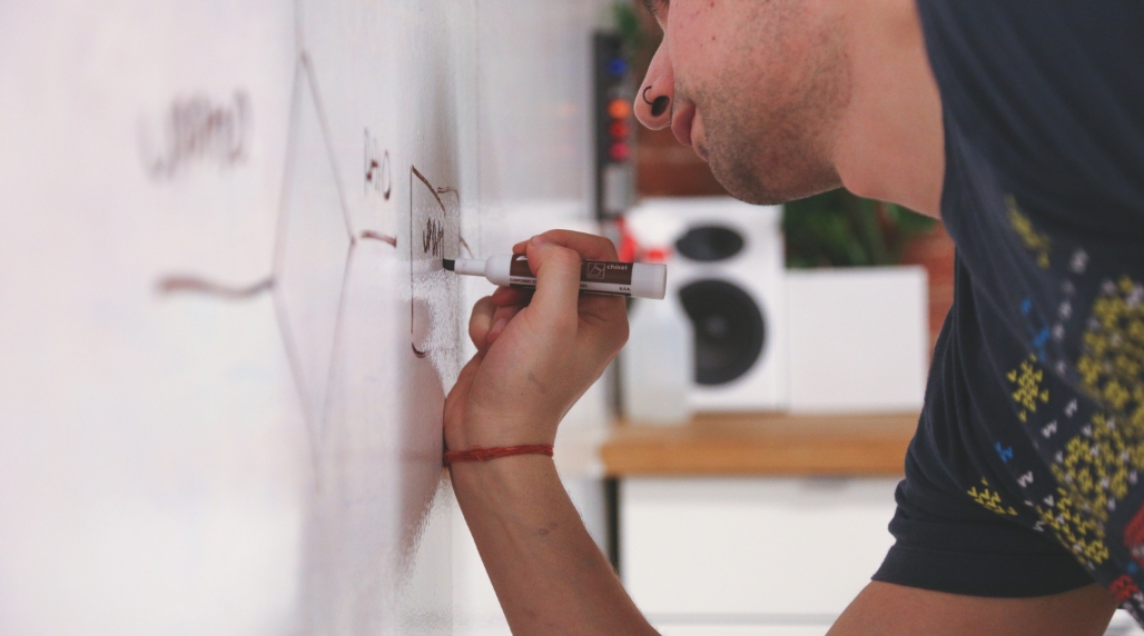 Man writing an equation on a whiteboard