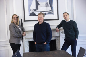 Justine Muir, Alan Crawley and Chris Foley standing in the Optima Partners boardroom